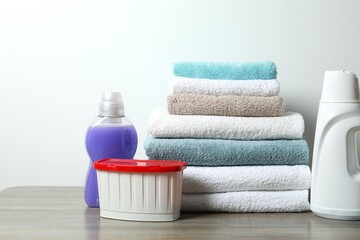 A stack of freshly washed towels and washing products on the table