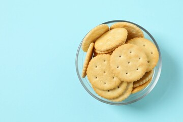 Delicious crispy crackers cookies on color background