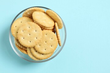 Delicious crispy crackers cookies on color background