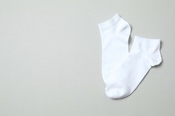 White socks on gray background, flat lay. 