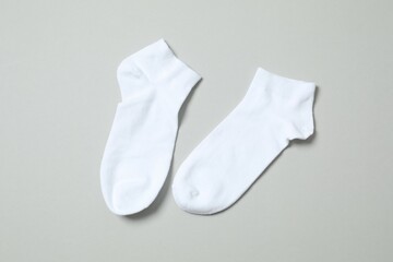 White socks on gray background, flat lay. 