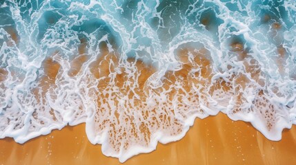 Fototapeta premium Overhead shot of foamy waves rolling onto a golden beach with clear copy space