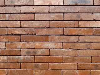 Aesthetically arranged patterned red brick wall texture. Red brick wall built in a house in the countryside with classic architecture. High resolution images.