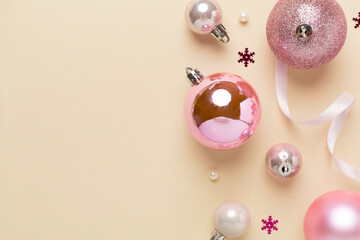 Pink christmas balls with decor on color background, top view