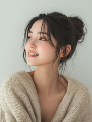 Smiling brunette woman with long hair and beautiful makeup, looking directly at the camera in a studio portrait