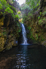 Waterfall along the beautiful trail PR6 Levada das 25 Fontes in Madeira during summer season. Portugal.