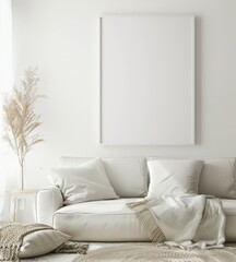 A minimalistic living room with a white sofa. a large framed canvas. and a dried plant The room is decorated with a beige rug and throw pillows