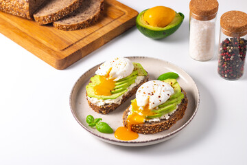 Two avocado open sandwiches with egg. Keto and diet concept. Healthy toast food for breakfast.