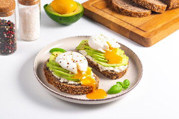 Two avocado open sandwiches with egg. Keto and diet concept. Healthy toast food for breakfast.