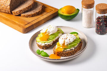 Two avocado open sandwiches with egg. Keto and diet concept. Healthy toast food for breakfast.