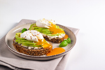 Two avocado open sandwiches with egg. Keto and diet concept. Healthy toast food for breakfast.