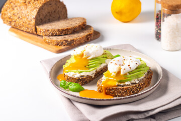 Two avocado open sandwiches with egg. Keto and diet concept. Healthy toast food for breakfast.