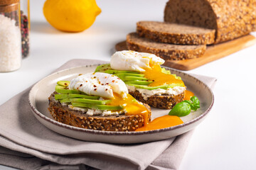 Two avocado open sandwiches with egg. Keto and diet concept. Healthy toast food for breakfast.