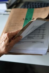 Naklejka premium Law; Process; Litigation- a hand reviewing the files of a civil case