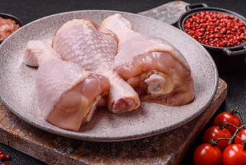 Raw chicken legs with salt, spices and herbs