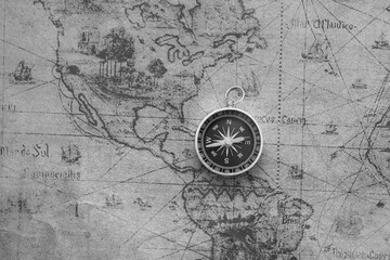 Classic round compass on background of old vintage map of world