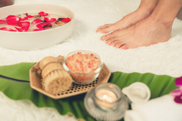 Woman indulges in blissful foot massage at luxurious spa salon while masseur give reflexology therapy in gentle day light ambiance resort or hotel foot spa. Quiescent
