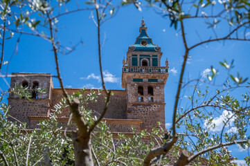 Cartuja de Valldemossa Mallorca, view from low angle with branches of a tree in front, majorca spain