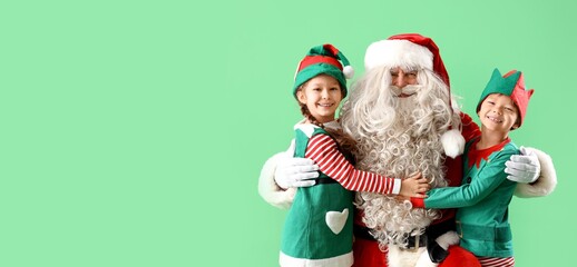 Little elves hugging Santa Claus on green background with space for text