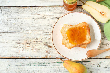 Naklejka premium Plate with tasty pear jam and bread on white wooden background