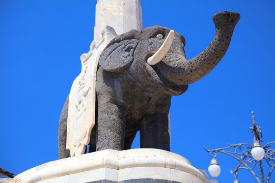 CATANIA, ITALY - AUGUST 14, 2024: Ancient elephant statue made of lava stone, known as U Liotru. It is the symbol of Catania, Italy, located at Piazza del Duomo city square.