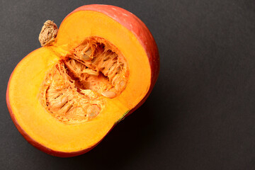 Cut fresh pumpkin on black background