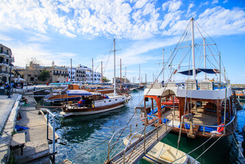 Obraz premium view of kyrenia town and boats in the harbor at the cyprus under cloudy blue sky