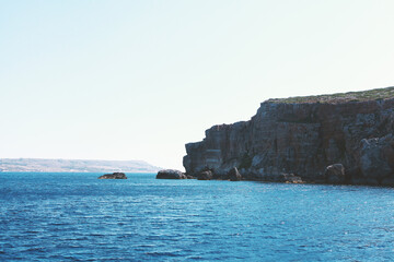 Landscape of rocky cliffs and the sea on a sunny day