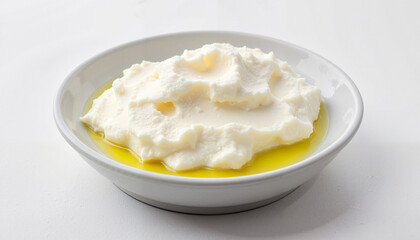 Creamy labneh cheese in white bowl with olive oil