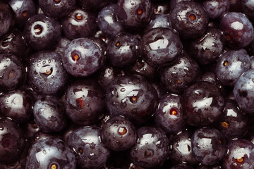 Wet acai berries as background, top view