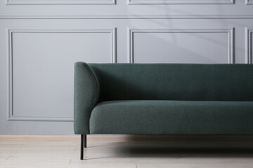 Comfortable sofa near grey wall in room