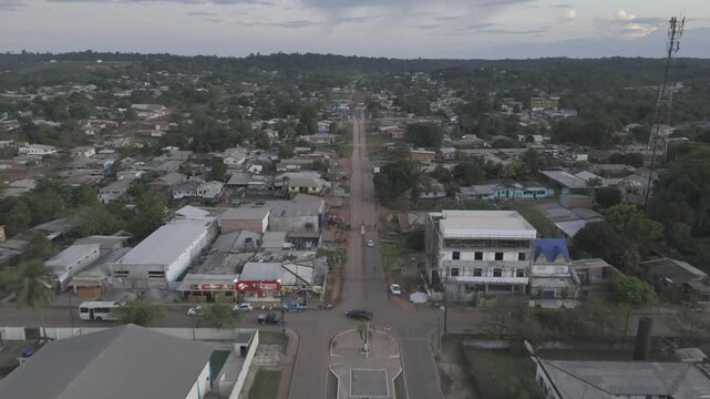 Drone flies along main street away from river in Oiapoque, Amap&aacute;, Brazil