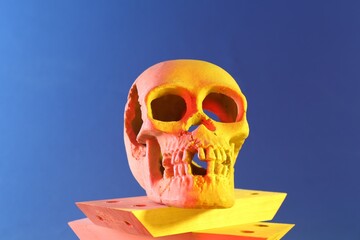 Human skull and wooden blocks on blue background