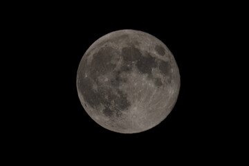The full moon surface close up that lights up in the night.
