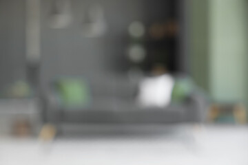 Comfortable sofa, carpet and hanging lamps in living room. Blurred view