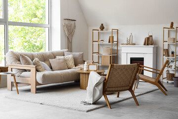Stylish interior of living room with sofa, rattan armchairs and coffee table