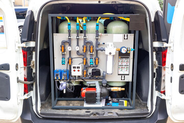 Portable water filtration system in van, showcasing industrial design and functionality of filtration equipment, water purification, technology concept