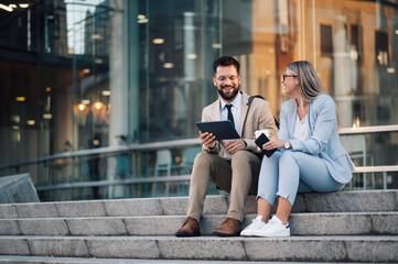 Business people talking and using tablet outdoors
