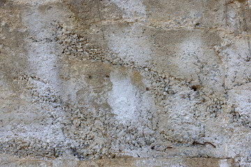 Textured Concrete Wall with Cracks and Pebbles, Weathered Stone Surface, Rugged Architecture, Concrete Texture Concept