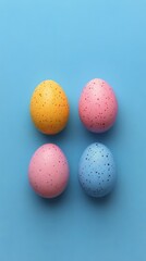 Colorful speckled eggs arranged on a blue surface for springtime decorations and celebrations