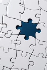 Fototapeta premium Close-Up of White Jigsaw Puzzle with One Piece Missing, Abstract Focus