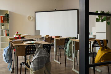 Interior of classroom with school desks and projector screen