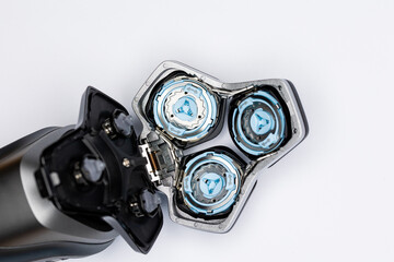 Beard  electric shaver on a white background. Inside view of the cutting blades . Photo taken in artificial light with clearly visible details of the shaver