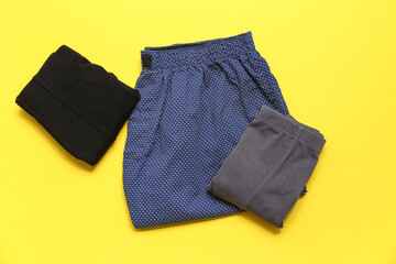 Stylish male trunks on yellow background