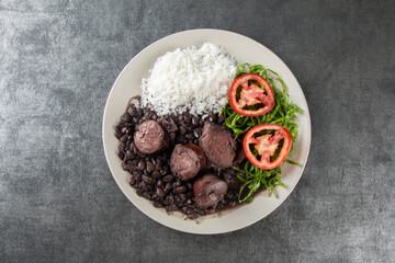 Plate with traditional Brazilian Feijoada with a gray background