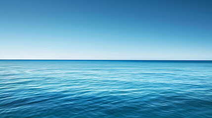 Deep blue ocean with a clear blue sky. The water is calm and still, with small waves rippling on the surface.