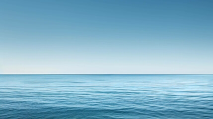 Obraz premium This is a beautiful image of a calm sea. The water is a deep blue color and the sky is a light blue color. The horizon is in the center of the image.