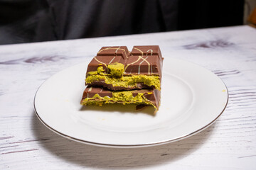 Dubai chocolate with pistachios on white plate in close-up