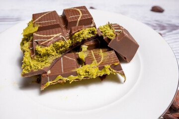 Dubai chocolate with pistachios on white plate in close-up