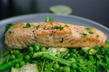 Pan fried salmon with warm green spring salad, fresh and healthy lunch, close up